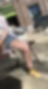 Candid chick wearing denim shorts chilling on the street bench spreading her legs