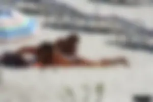 Topless milf and her topless daughter on the beach