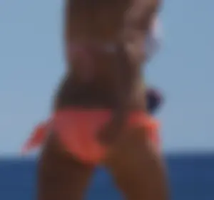 Thick blonde girl in an orange bikini on the beach