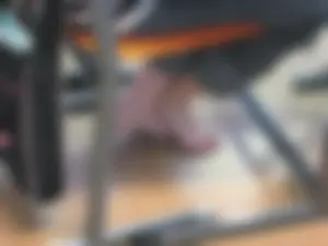 Teen college girl's bare feet under desk in classroom closeup