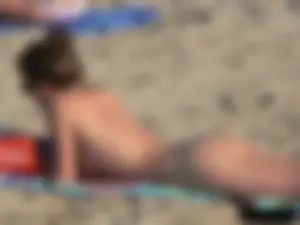 Sexy babe with a nice body topless and in a thong on the beach