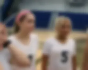Bunch of cute college girls in bright pink shorts playing volleyball