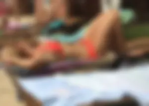 Sexy blonde lady in a bikini with a great body laying by the pool
