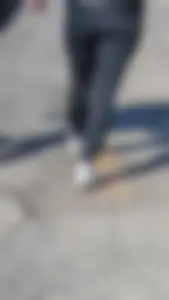 A beautiful little brunette walking in the park. tight black leggings