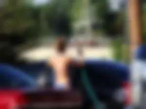 Group of cute girls at a car wash in bikinis and shorts
