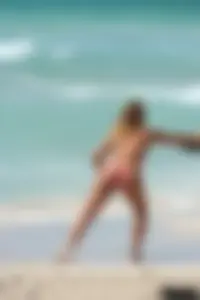 Topless girl in a tiny thong on the beach playing paddle ball