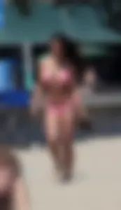 Sexy brunette on the beach in a bikini with great tits