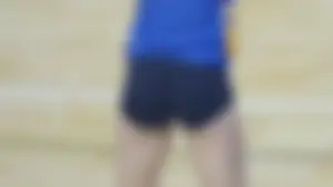 Pretty and sexy brunette college girl in spandex shorts playing volleyball