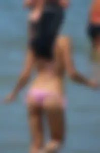 Little brunette ass in a pink bikini at the beach