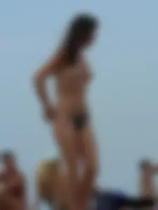 Sexy babe with a nice body topless and in a thong on the beach