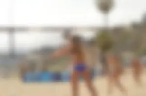 Sexy beach volleyball girl in sport bra top with pokies and blue bikini bottom