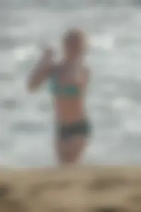 Blonde lady on the beach in bikini top and spandex shorts with a nice gap