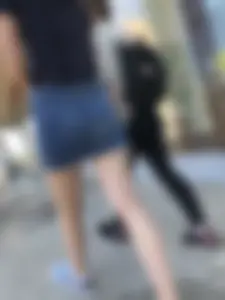 Cute Girl in a Short Denim Skirt Walking on a Street And Waiting on a Crosswalk Gallery