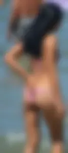 Little brunette ass in a pink bikini at the beach