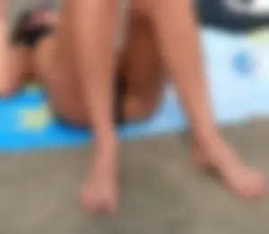 Lady in black bikini showing some pubes while laying out