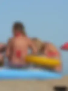 Sexy mom and daughter in red thongs at the beach