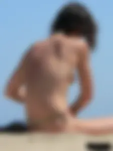 Topless beach milf looking sexy in a tiny g-string bikini