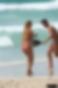 Topless girl in a tiny thong on the beach playing paddle ball