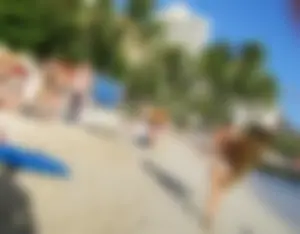 Skinny blonde surfer on the beach in little bikini