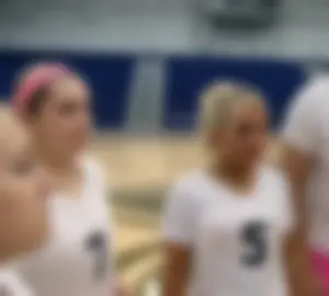 Bunch of cute college girls in bright pink shorts playing volleyball