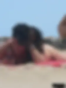 Brunette lady topless and in a black thong on the beach