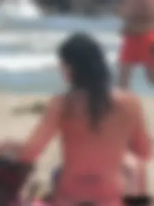 Brunette lady topless and in a black thong on the beach