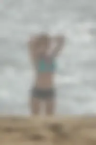 Blonde lady on the beach in bikini top and spandex shorts with a nice gap
