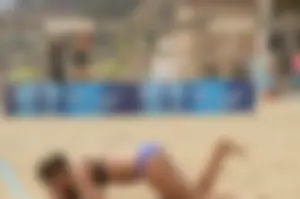 Sexy beach volleyball girl in sport bra top with pokies and blue bikini bottom