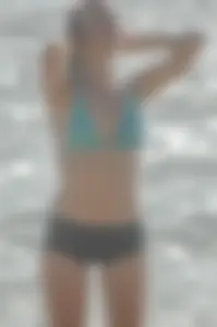 Blonde lady on the beach in bikini top and spandex shorts with a nice gap