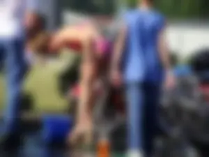 Group of cute girls at a car wash in bikinis and shorts