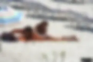 Topless milf and her topless daughter on the beach
