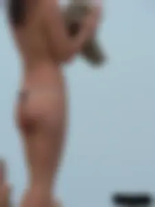 Sexy babe with a nice body topless and in a thong on the beach