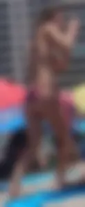 Sexy milf at the beach in a colorful semi thong bikini