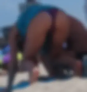 Sexy milf at the beach in a colorful semi thong bikini