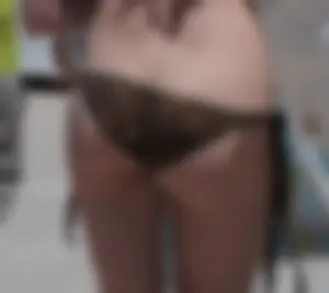 Girl in a tiny brown floral bikini showing some cheek and crack
