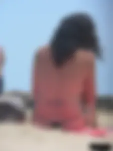 Brunette lady topless and in a black thong on the beach