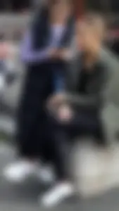 Cute candid street girl sitting with crossed legs
