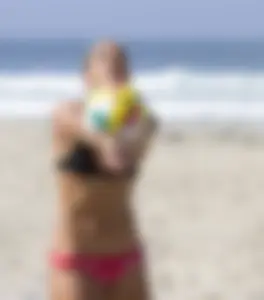 Hot girls playing beach volleyball in bikinis and shorts