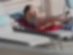 Sexy ass brunette sunbathing by the pool in thong bikini