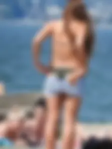 Beach babe taking off her shorts and shirt showing her bikini and sexy body