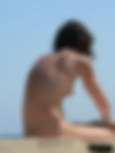 Topless beach milf looking sexy in a tiny g-string bikini