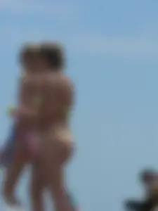 Sexy blonde on the beach in a yellow thong bikini