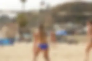 Sexy beach volleyball girl in sport bra top with pokies and blue bikini bottom