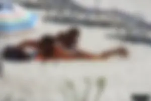 Topless milf and her topless daughter on the beach