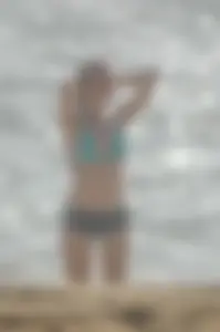 Blonde lady on the beach in bikini top and spandex shorts with a nice gap
