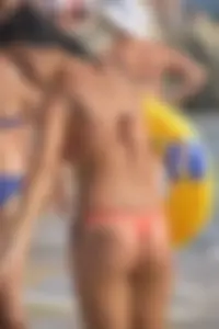 Orange thong bikini brunette sexy on the beach and showing some camel toe