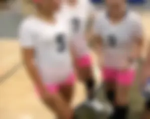 Bunch of cute college girls in bright pink shorts playing volleyball