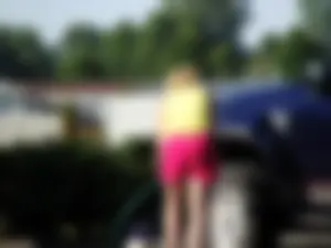 Group of cute girls at a car wash in bikinis and shorts