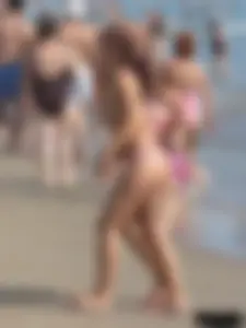 Topless tattooed lady at the beach with a nice ass in pink thong bikini