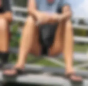 Girl in Shorts And Slippers Sitting With Spread Legs at a Street Sporting Ground Creepshot - Her Crotch Clearly Visible